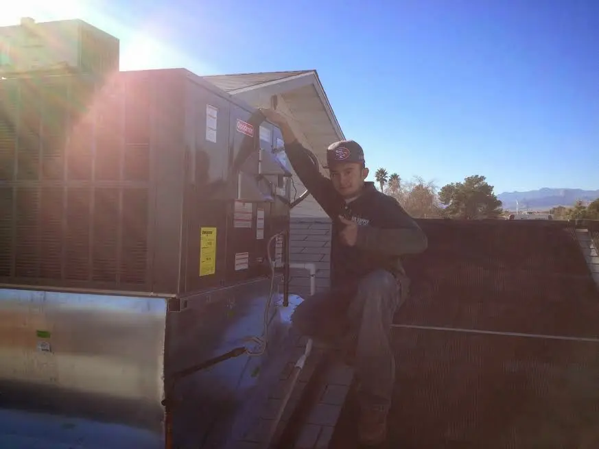 HVAC technician performing HVAC Inspection on a rooftop unit in Old Westbury